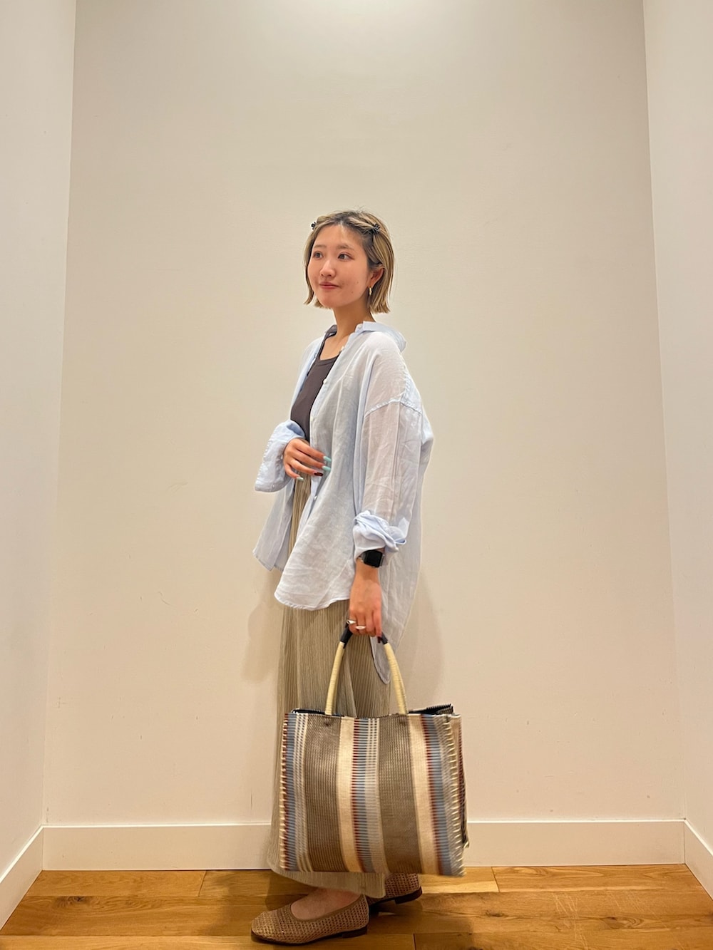ベージュ系のスカート、ブルー系のシャツ/ブラウスを着用したレディースの夏コーディネートの2枚目の写真