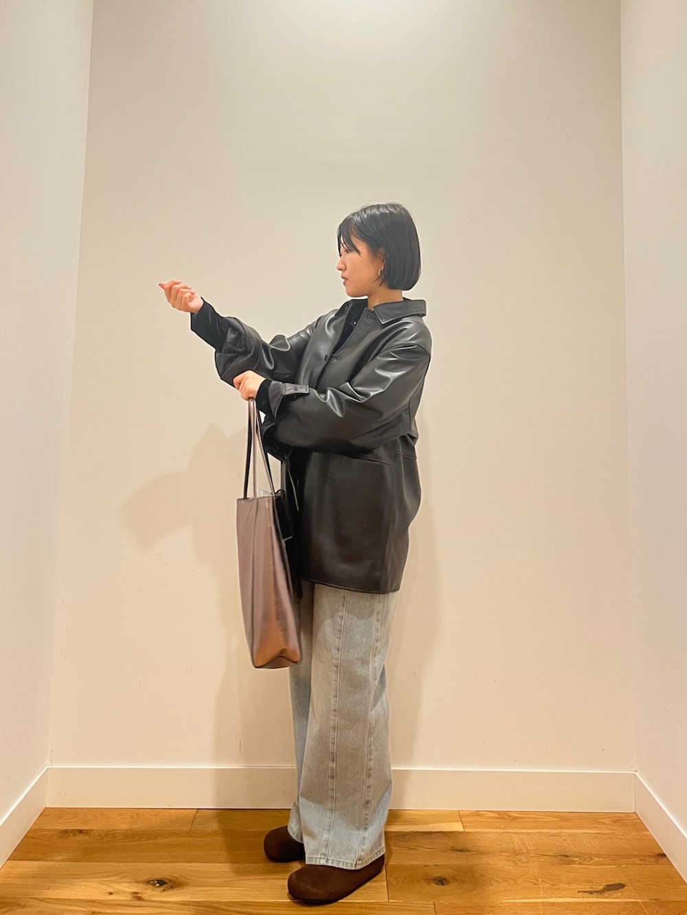 ブラック系のカーディガン/ボレロ、ブラック系のその他アウター、ブルー系のデニムパンツを着用したレディースの秋コーディネートの2枚目の写真