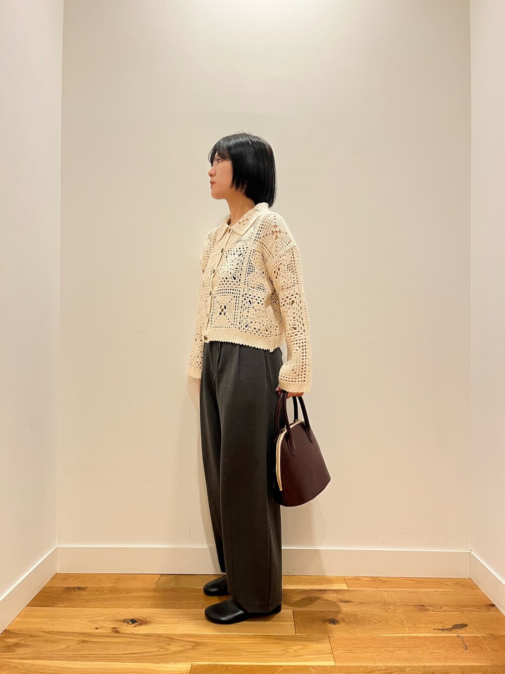 ベージュ系のカーディガン/ボレロ、グレー系のその他パンツ、レッド系のハンドバッグを着用したレディースの秋コーディネートの2枚目の写真