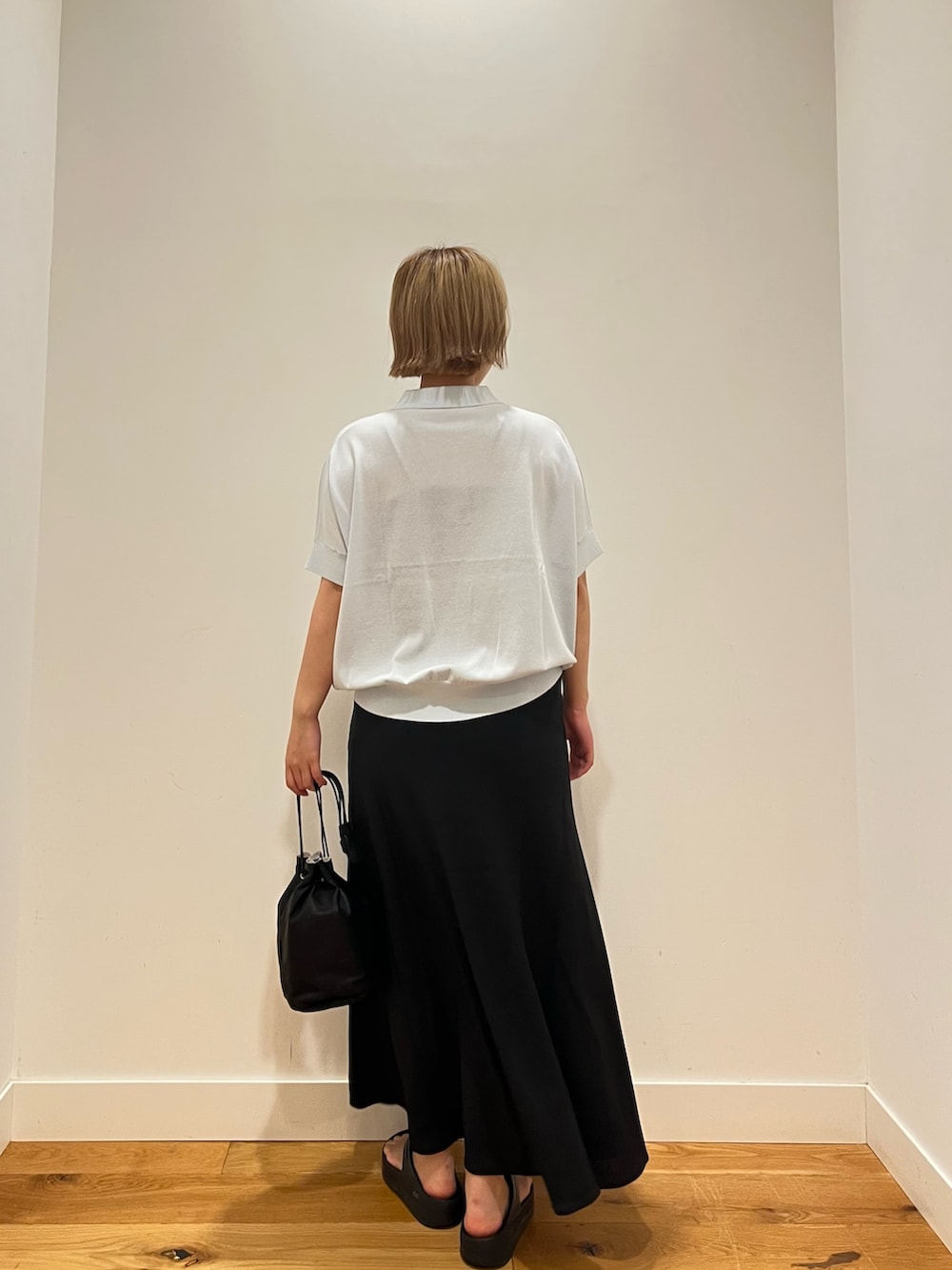 ブラック系のスカート、ブルー系のニット/セーターを着用したレディースの夏コーディネートの3枚目の写真