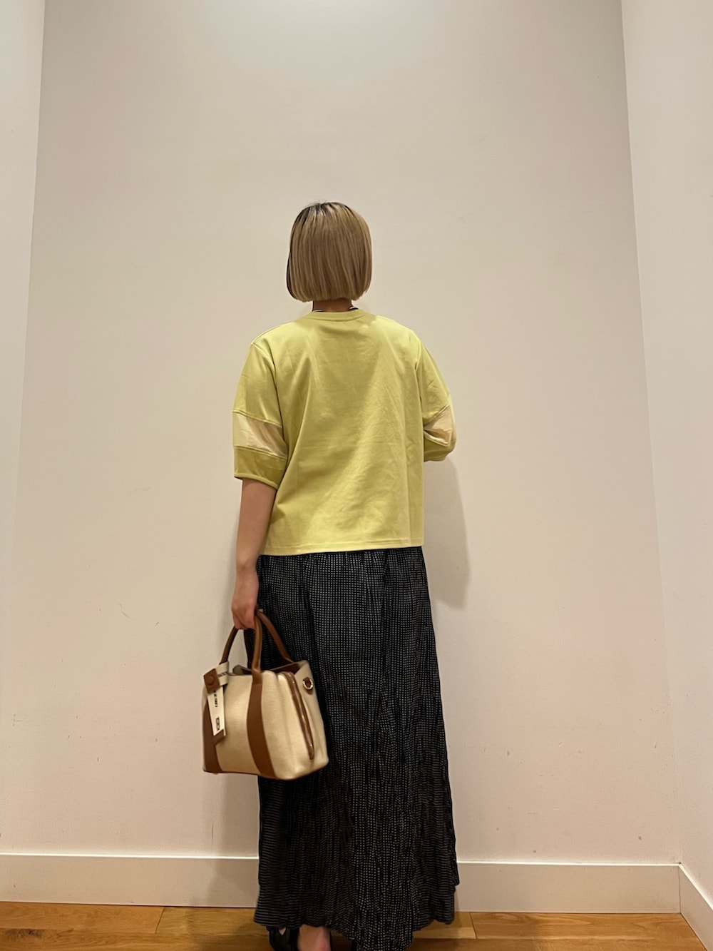 グリーン系のTシャツ/カットソー、ブラック系のスカートを着用したレディースの夏コーディネートの2枚目の写真