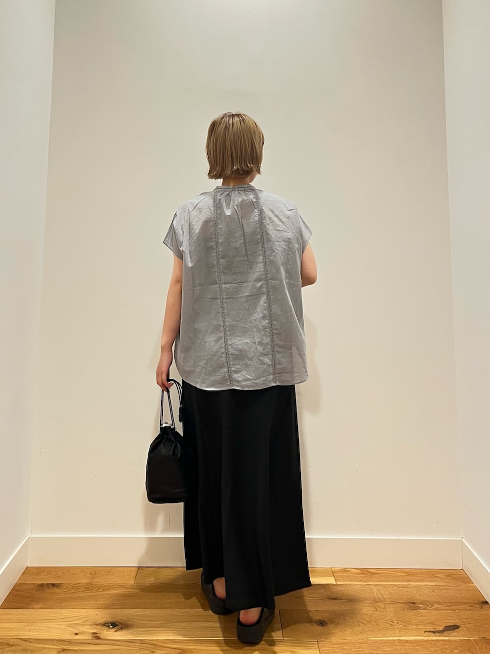 グレー系のシャツ/ブラウス、ブラック系のスカート、ブラック系のショルダーバッグを着用したレディースの夏コーディネートの3枚目の写真