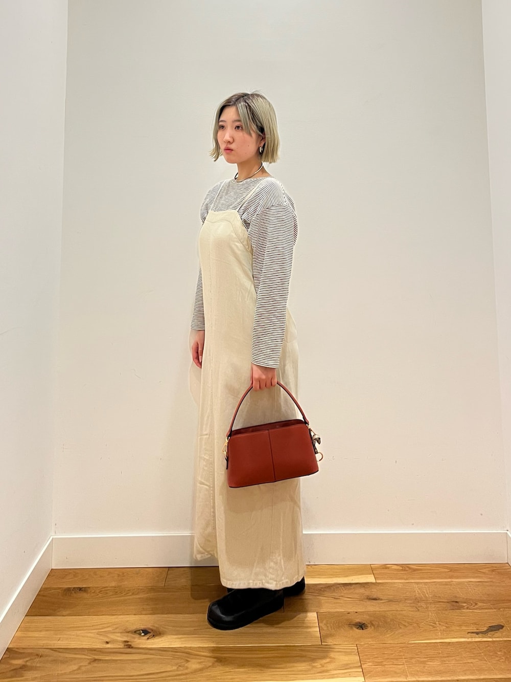 オレンジ系のショルダーバッグ、グレー系のワンピースを着用したレディースの春コーディネートの2枚目の写真