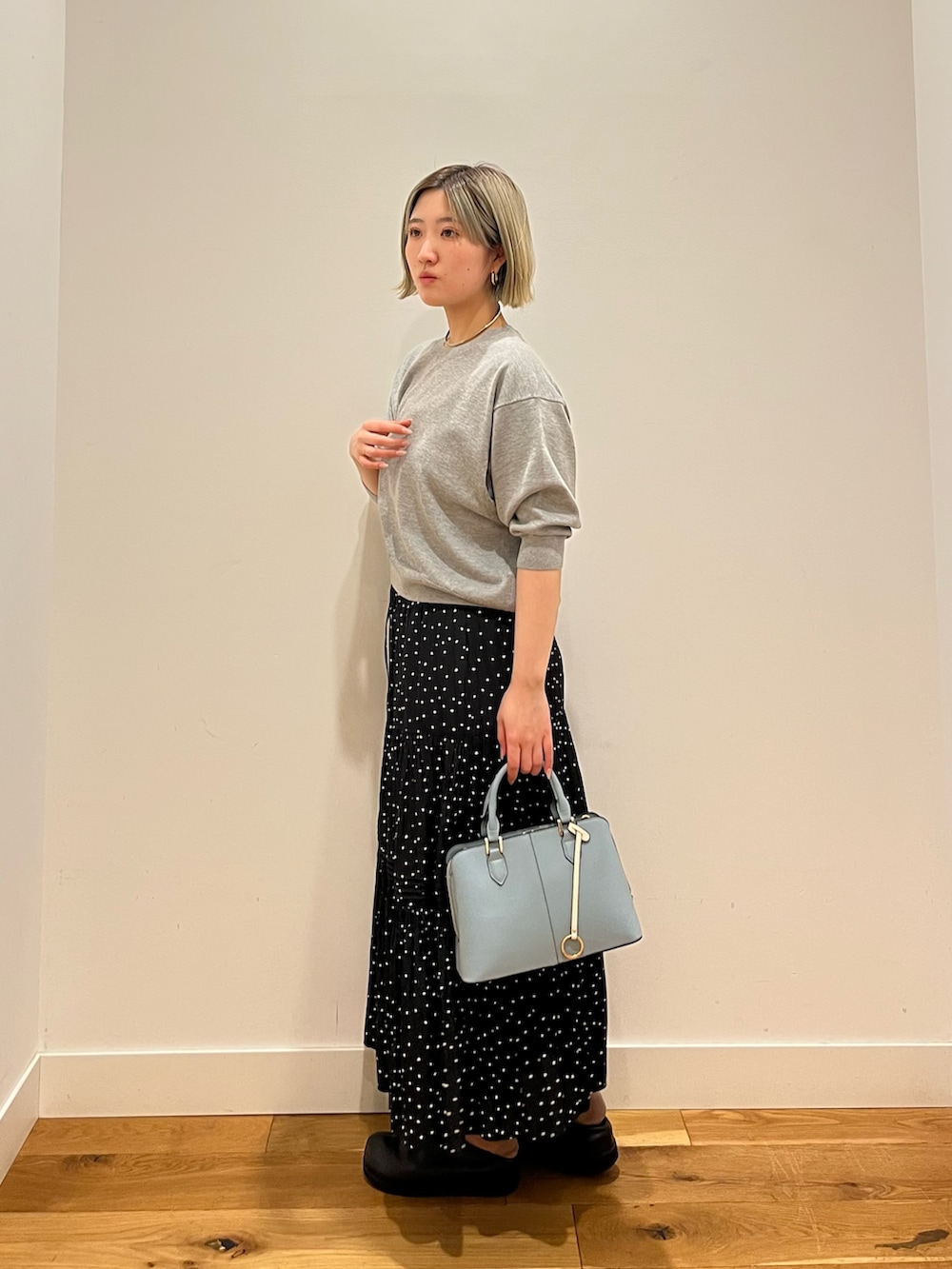 ブラック系のスカート、グレー系のTシャツ/カットソーを着用したレディースの春コーディネートの2枚目の写真