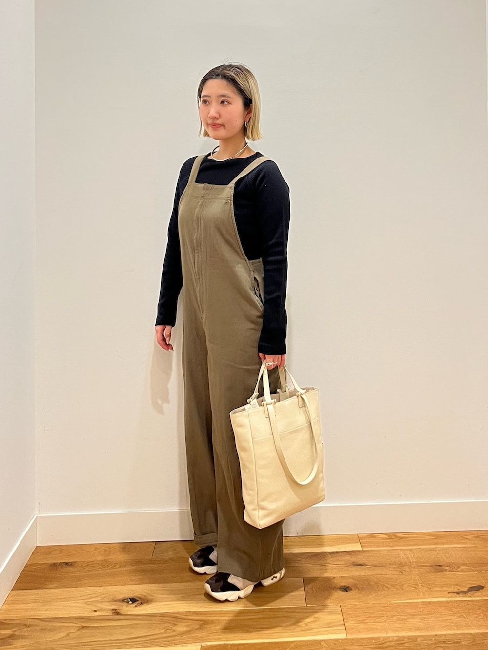 ブラック系のTシャツ/カットソー、グリーン系のサロペット/オーバーオールを着用したレディースの春コーディネートの2枚目の写真