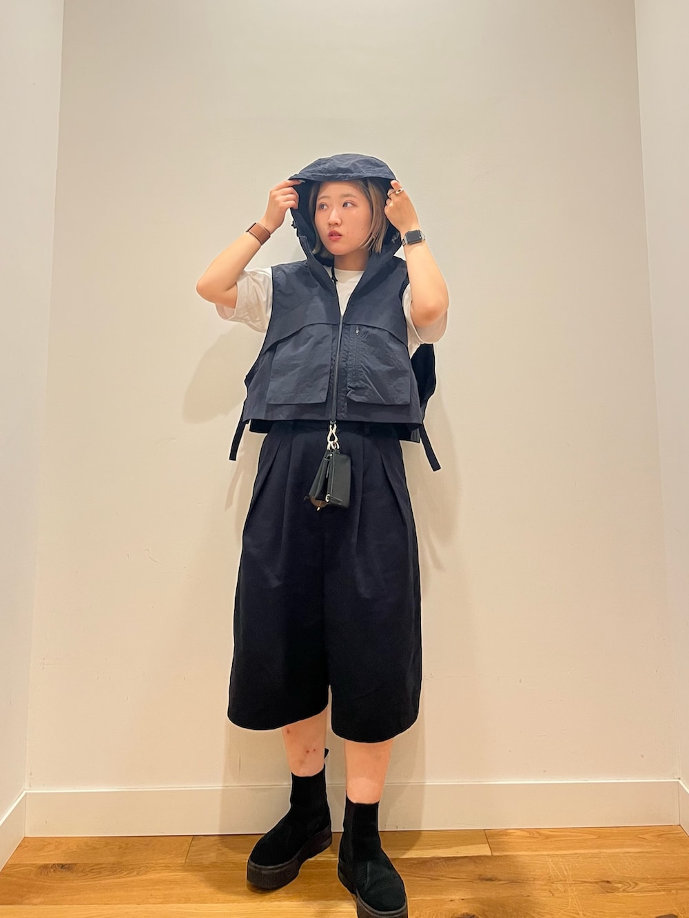 ブルー系のベスト、ブラック系のその他パンツを着用したレディースの夏コーディネートの3枚目の写真