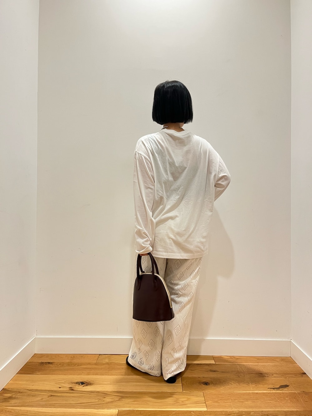 ホワイト系のTシャツ/カットソー、ホワイト系のその他パンツ、ブラック系のその他シューズを着用したレディースの秋コーディネートの3枚目の写真