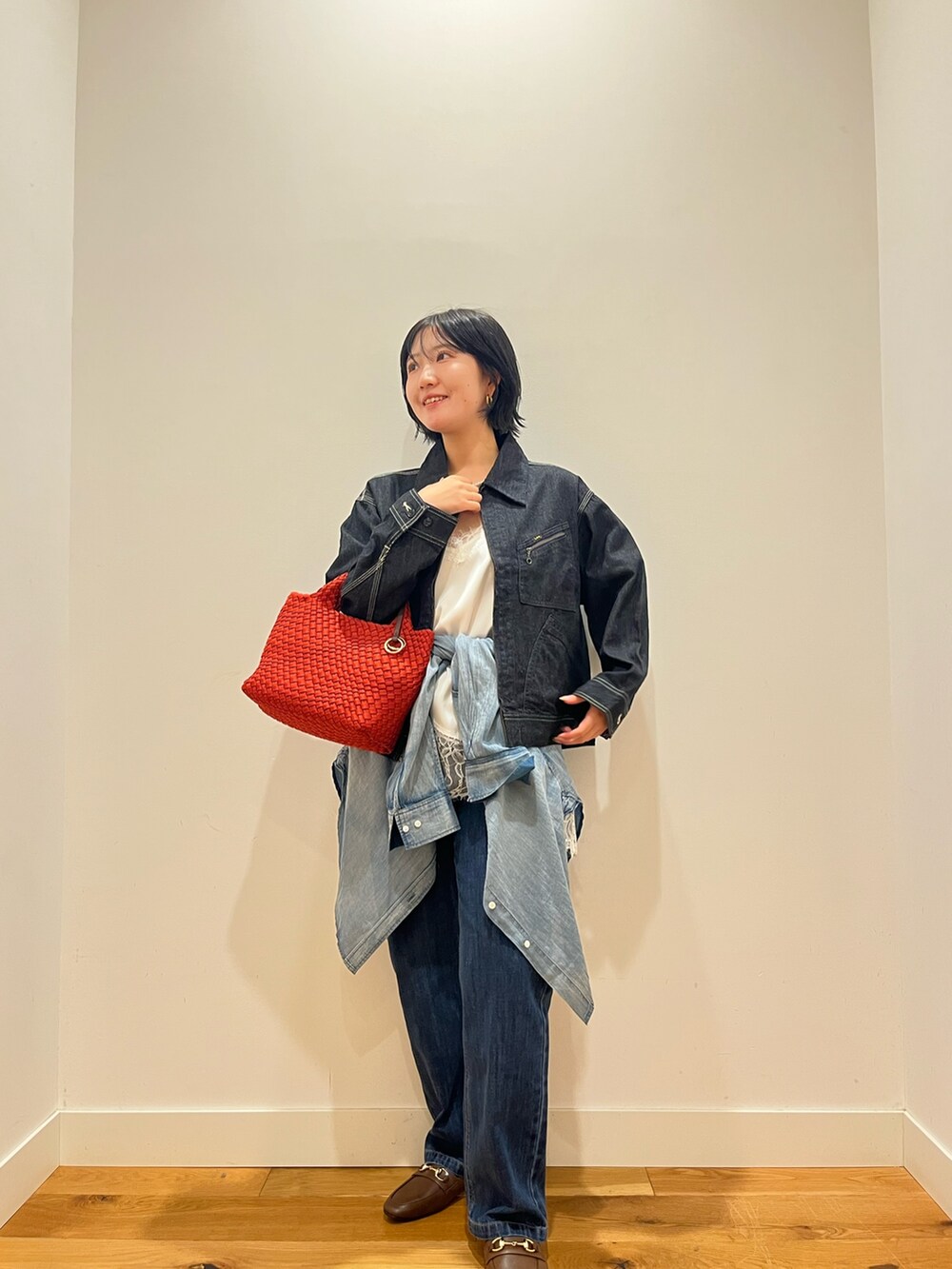 ブルー系のデニムパンツ、ブルー系のシャツ/ブラウス、ホワイト系のキャミソールを着用したレディースの秋コーディネートの4枚目の写真