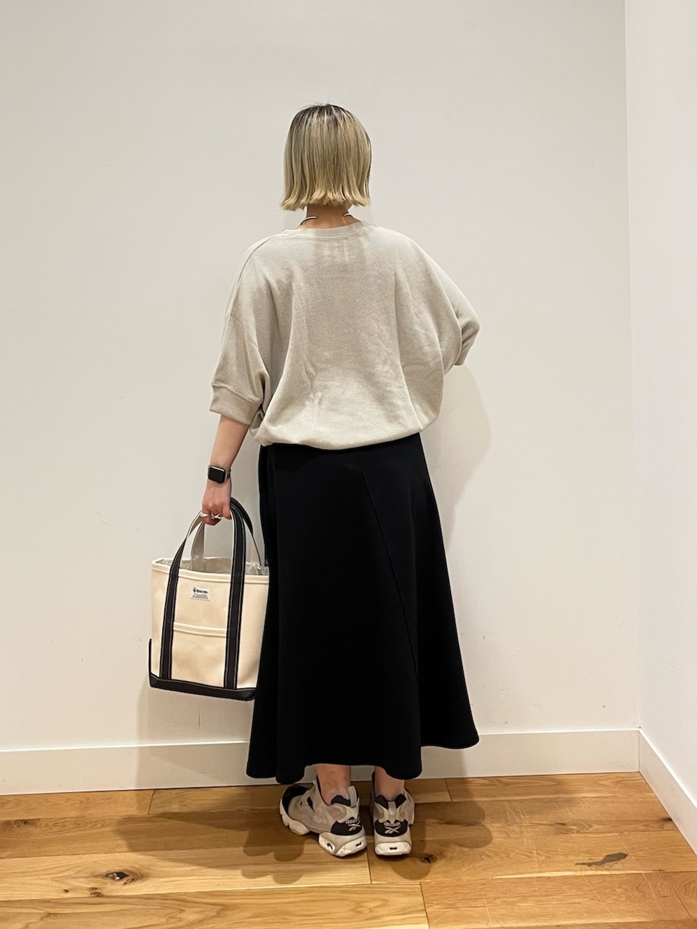 ベージュ系のTシャツ/カットソー、ブラック系のスカートを着用したレディースの春コーディネートの3枚目の写真