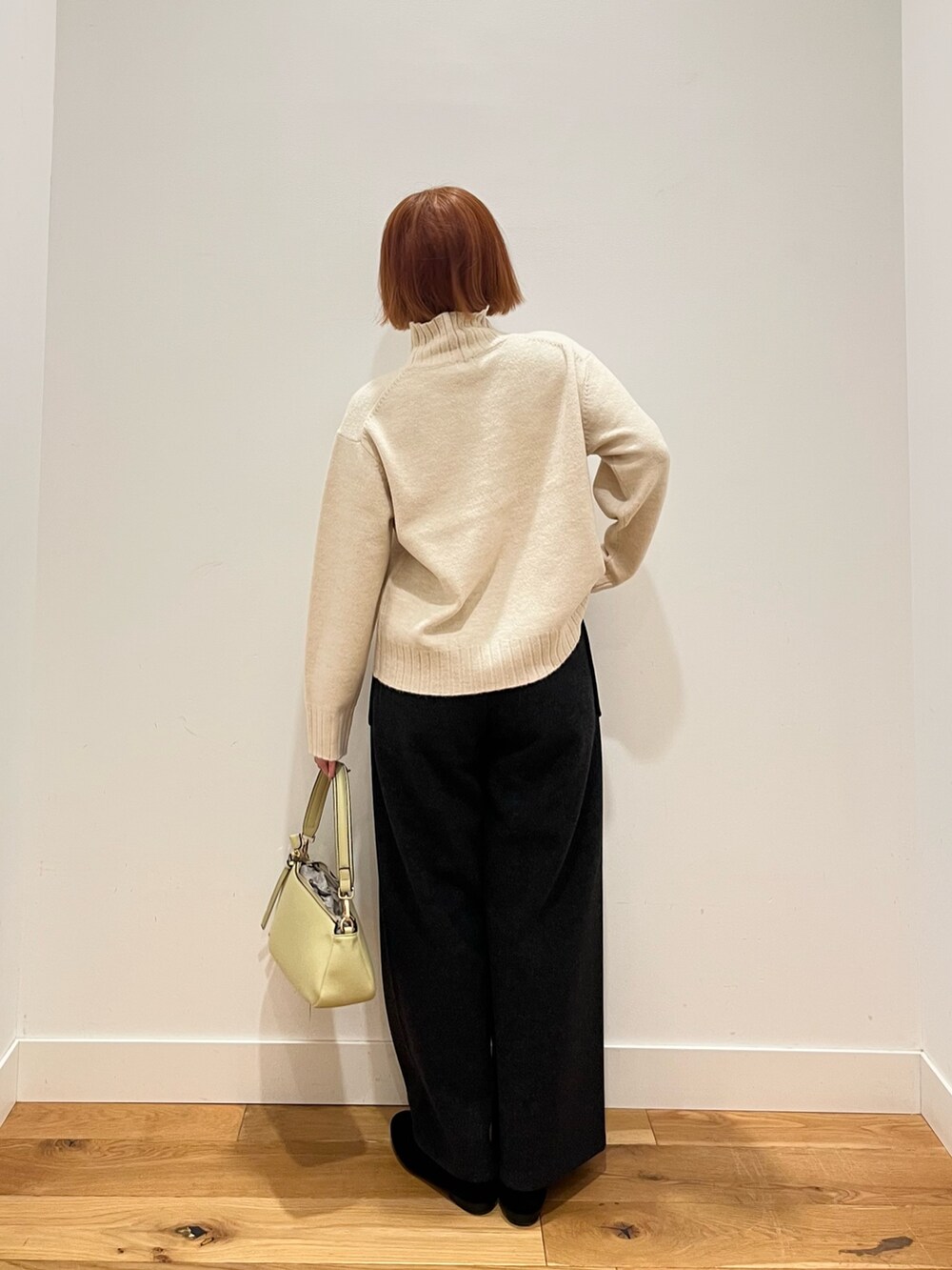 ホワイト系のニット/セーター、イエロー系のバッグ、グレー系のその他パンツを着用したレディースの冬コーディネートの3枚目の写真