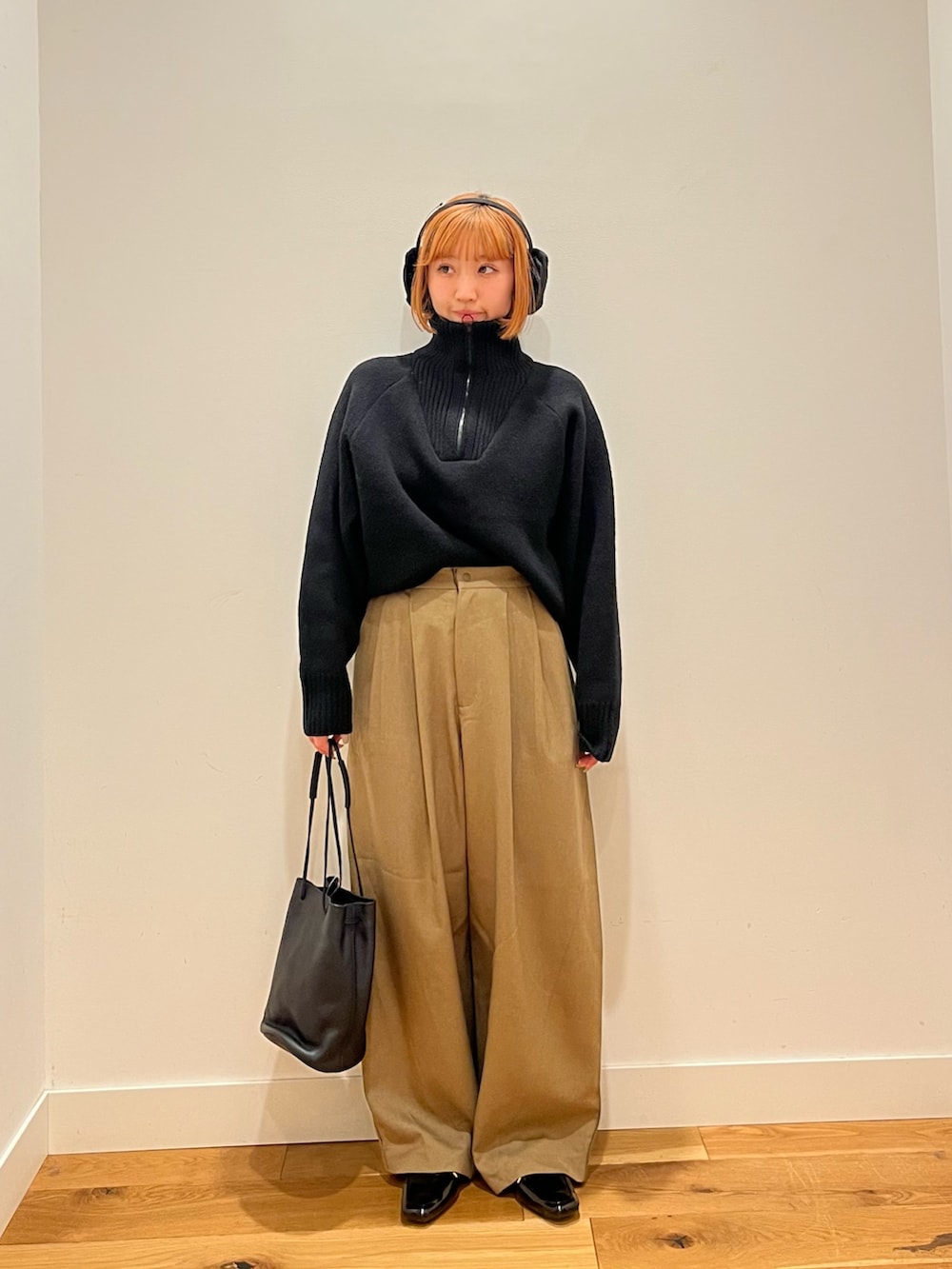 ブラック系のショルダーバッグ、イエロー系のその他パンツ、ブラック系のニット/セーターを着用したレディースの冬コーディネートの2枚目の写真