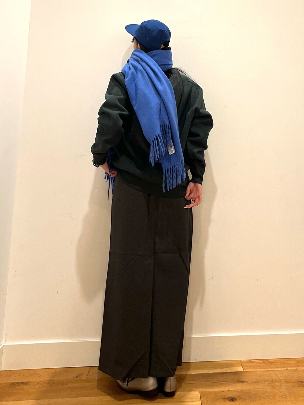 グレー系のスカート、グリーン系のショルダーバッグ、グリーン系のパーカーを着用したレディースの秋コーディネートの3枚目の写真