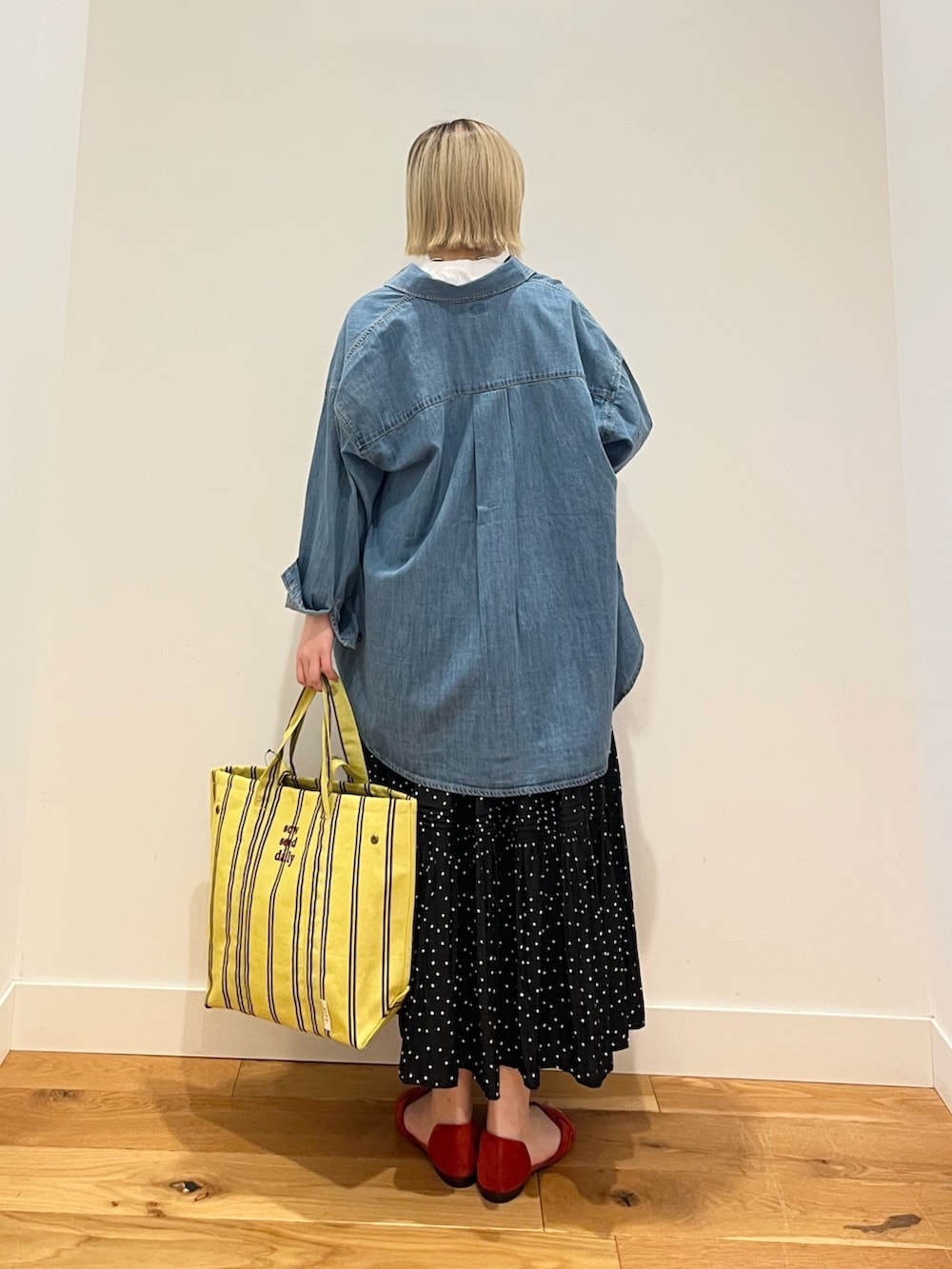 ブラック系のスカート、ブルー系のシャツ/ブラウス、ホワイト系のTシャツ/カットソーを着用したレディースの春コーディネートの3枚目の写真