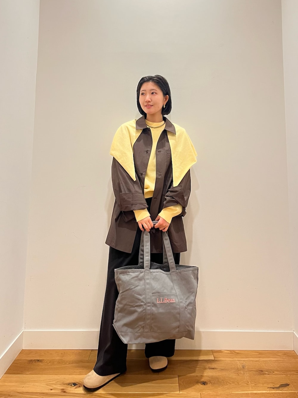 イエロー系のニット/セーター、グレー系のシャツ/ブラウス、グレー系のトートバッグを着用したレディースの秋コーディネートの3枚目の写真