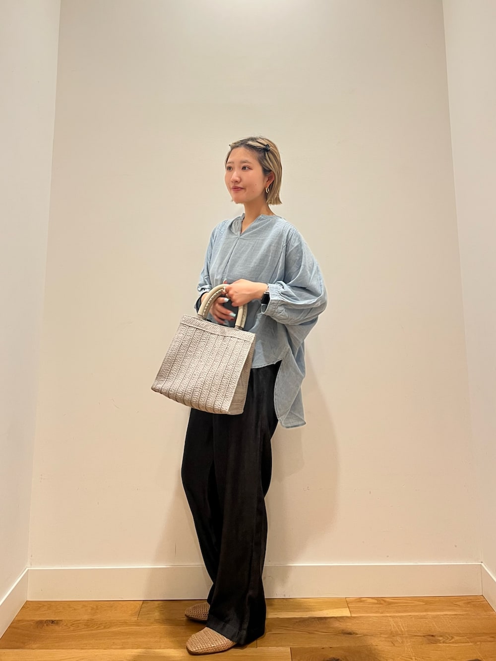 ブルー系のシャツ/ブラウス、ブラック系のデニムパンツ、グレー系のハンドバッグを着用したレディースの夏コーディネートの2枚目の写真