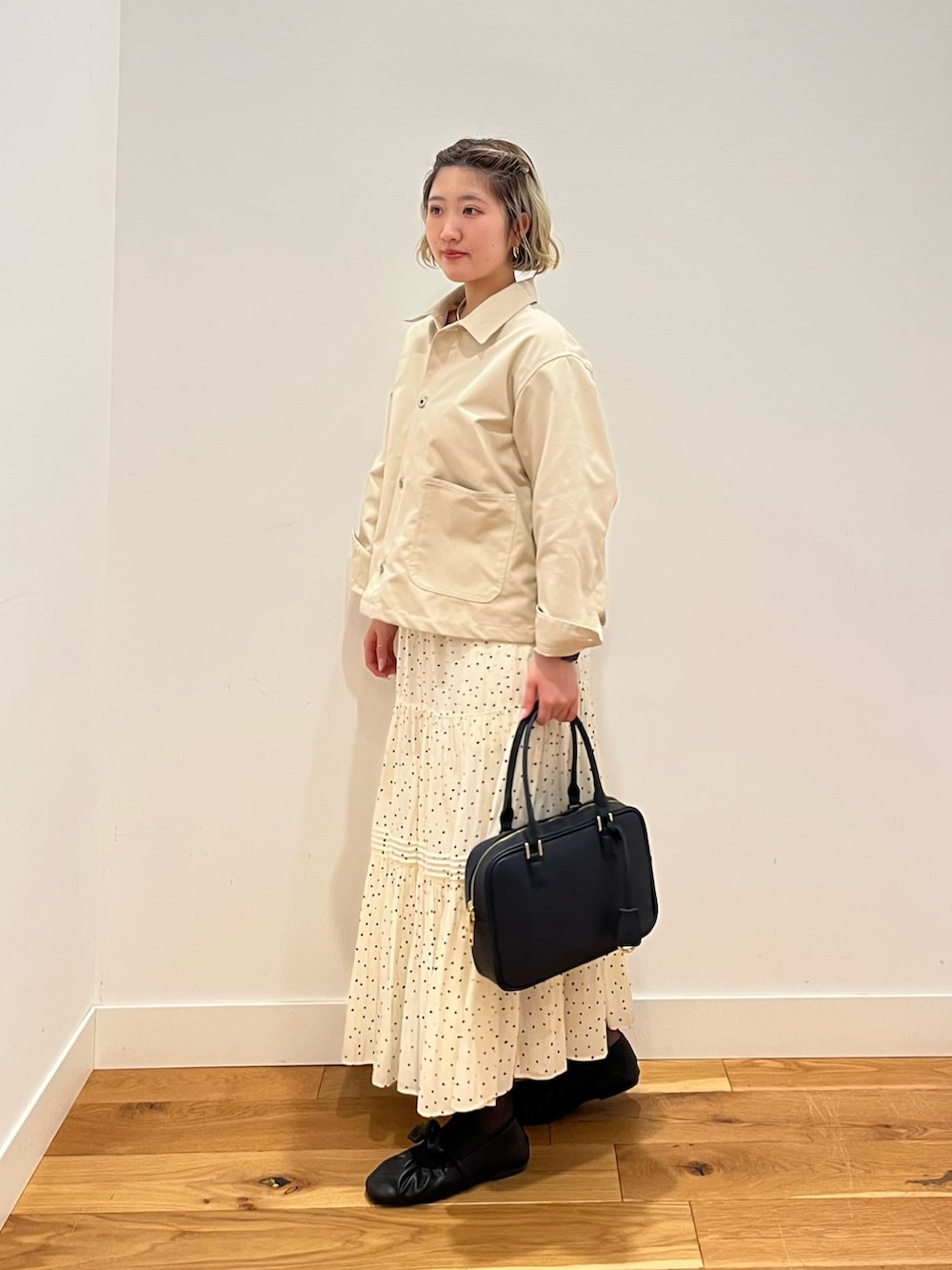 ホワイト系のスカート、ホワイト系のカバーオールを着用したレディースの春コーディネートの2枚目の写真