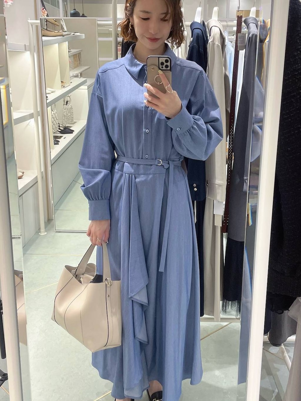 ホワイト系のトートバッグ、ブルー系のワンピースを着用したレディースの春コーディネートの2枚目の写真