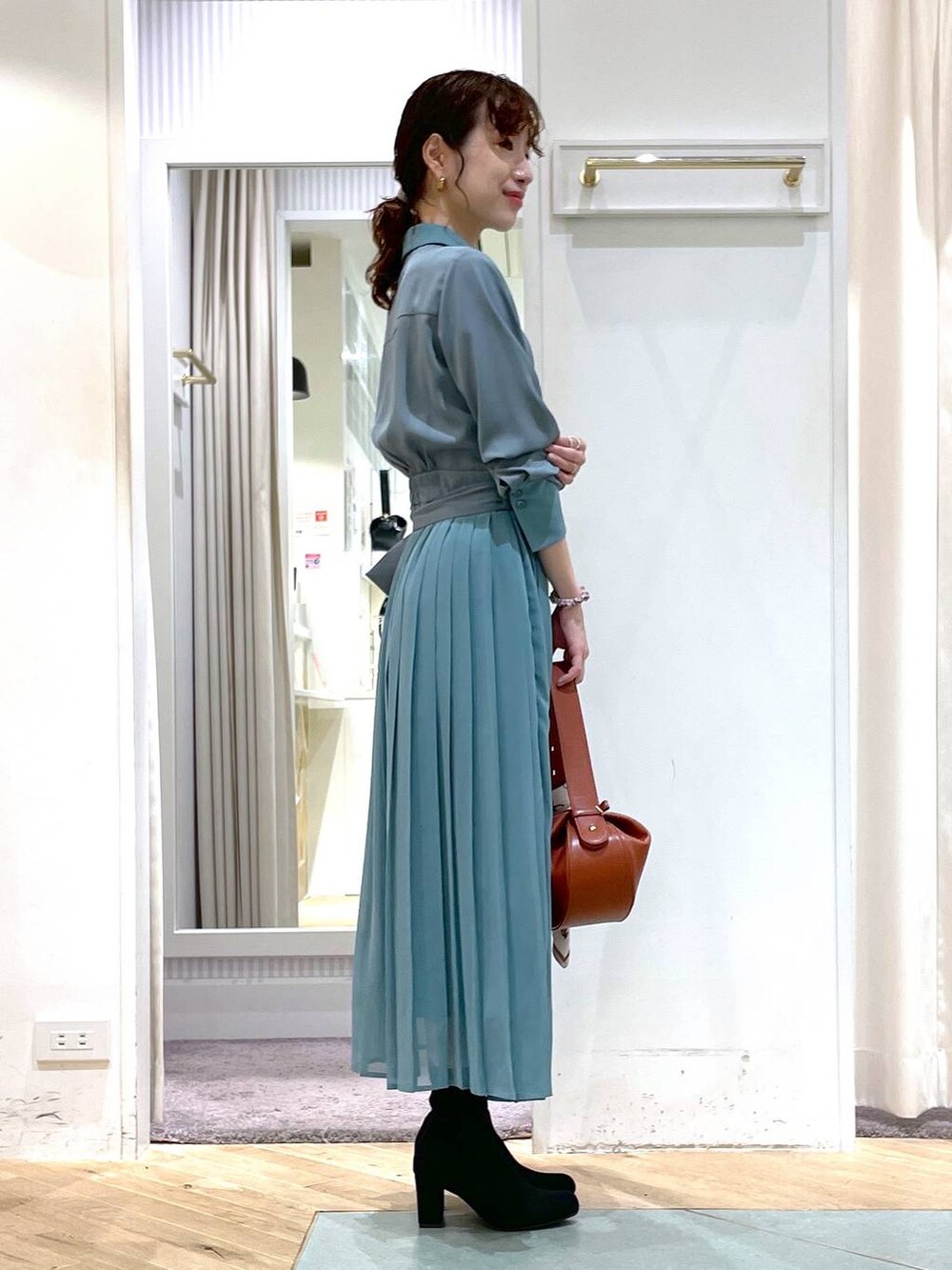 グリーン系のシャツワンピース、ブラウン系のショルダーバッグ、ベージュ系のバンダナ/スカーフを着用したレディースの夏コーディネートの3枚目の写真