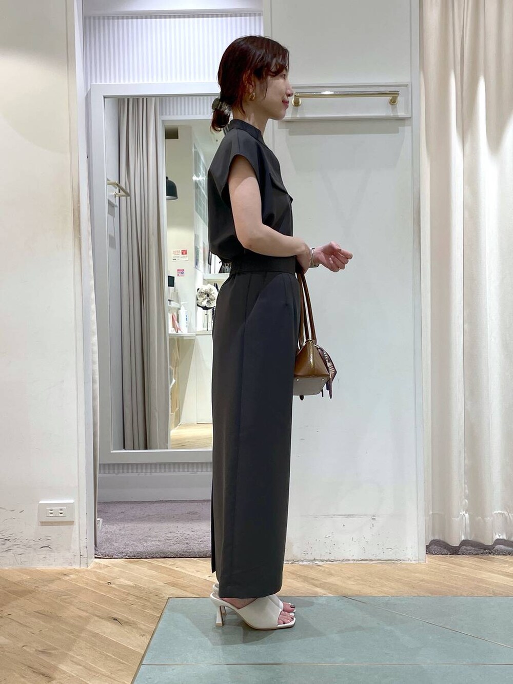 ブラウン系のボストンバッグ、グレー系のシャツ/ブラウス、グレー系のスカートを着用したレディースの夏コーディネートの4枚目の写真