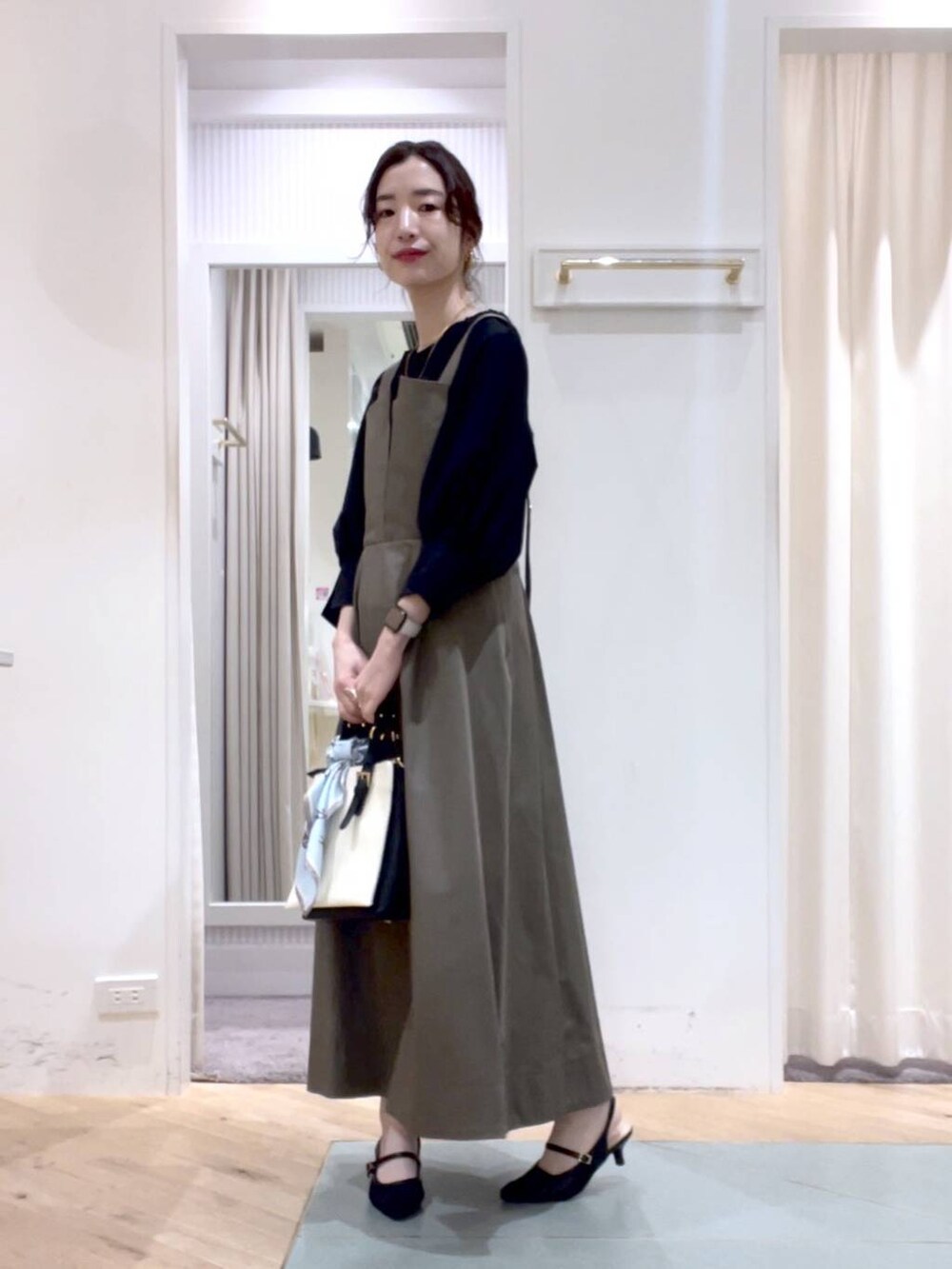 その他のサンダル、ブラック系のトートバッグ、ブラウン系のジャンパースカートを着用したレディースの春コーディネートの3枚目の写真