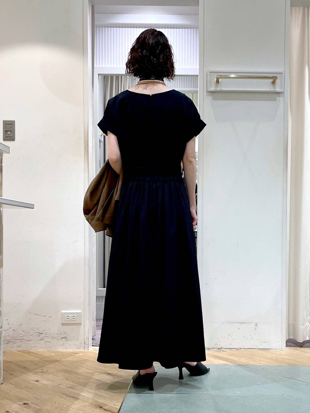 ブラック系のサンダル、ブラウン系のテーラードジャケット、ブラック系のワンピースを着用したレディースの春コーディネートの3枚目の写真