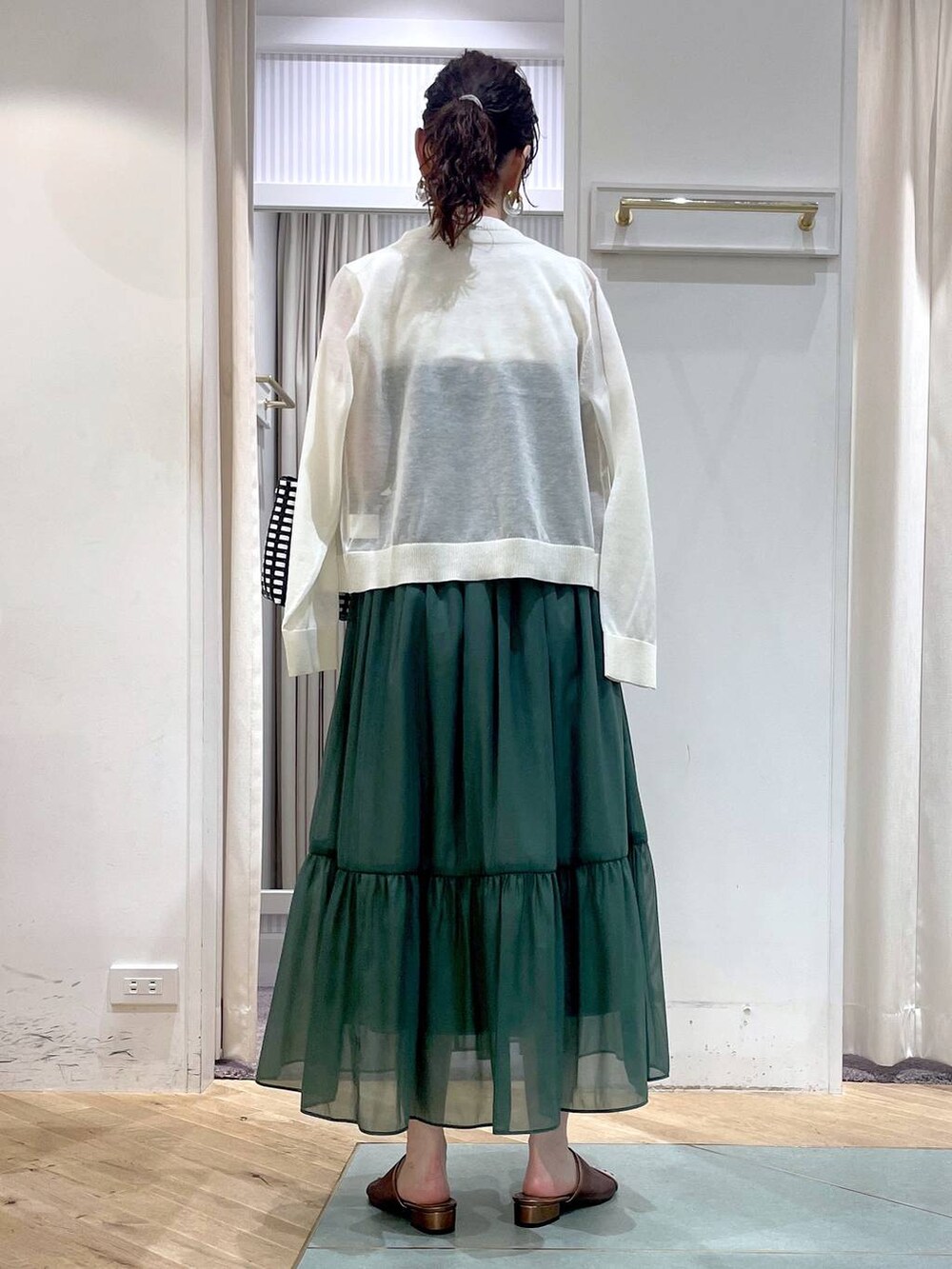 ブラック系のかごバッグ、ホワイト系のカーディガン/ボレロ、ホワイト系のニット/セーターを着用したレディースの夏コーディネートの3枚目の写真