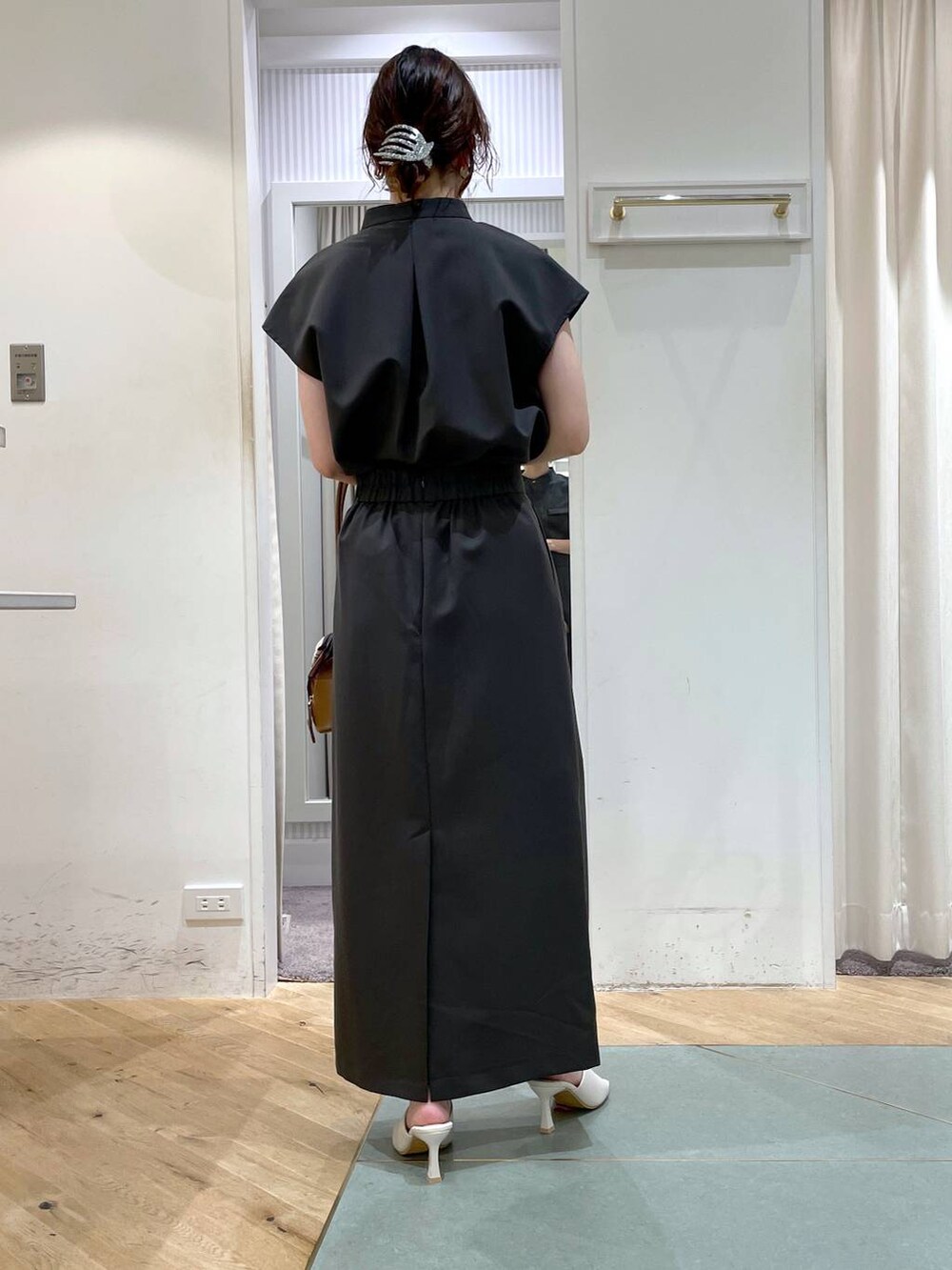 ブラウン系のボストンバッグ、グレー系のシャツ/ブラウス、グレー系のスカートを着用したレディースの夏コーディネートの5枚目の写真