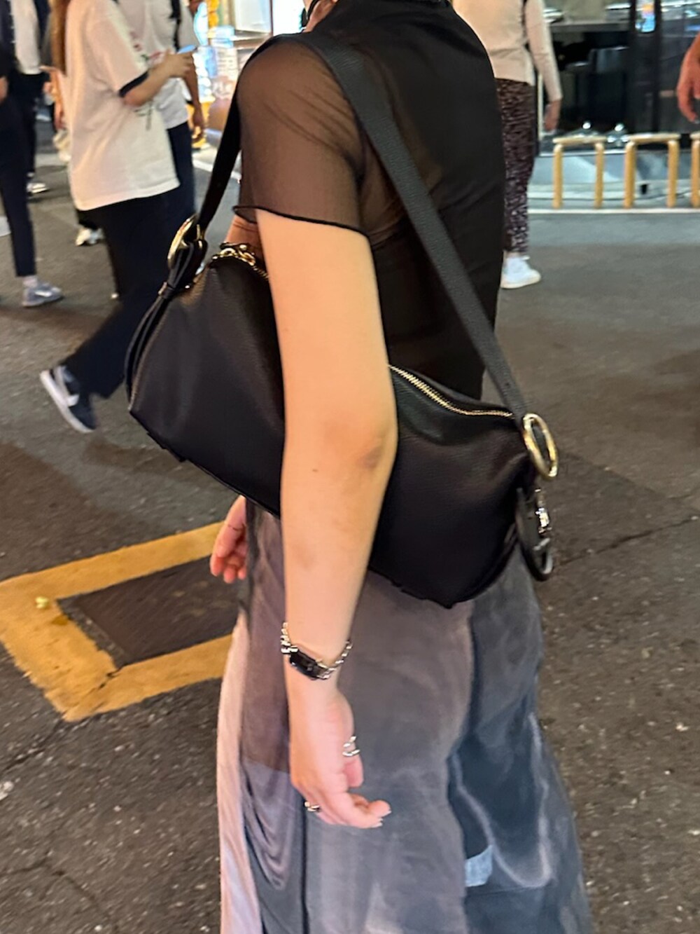 ブラック系のハンドバッグ、ブラック系のスニーカー、ブラック系のパンツを着用したレディースの秋コーディネートの3枚目の写真