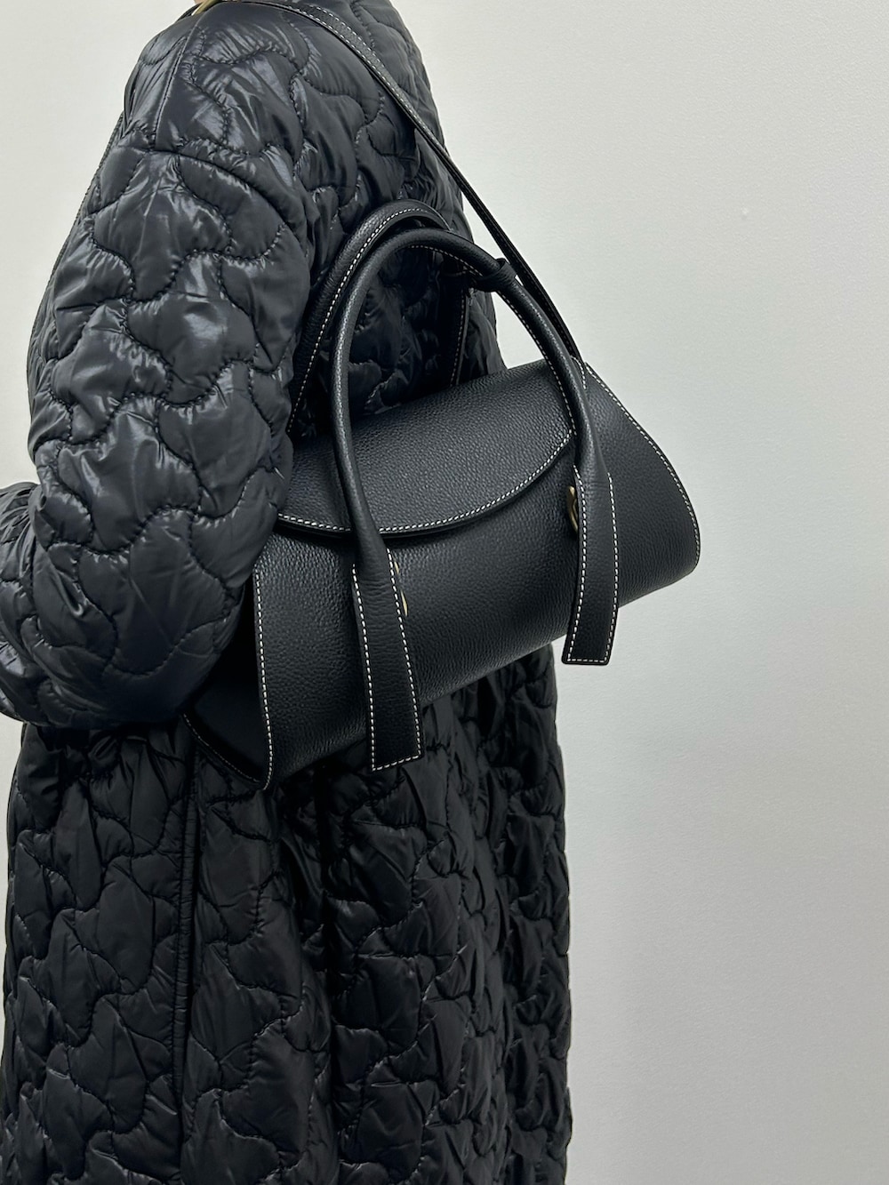 ブラック系のハンドバッグを着用したレディースの冬コーディネートの3枚目の写真