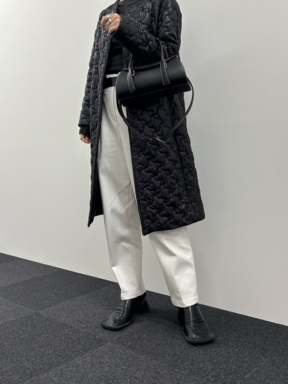 ブラック系のハンドバッグを着用したレディースの冬コーディネートの2枚目の写真