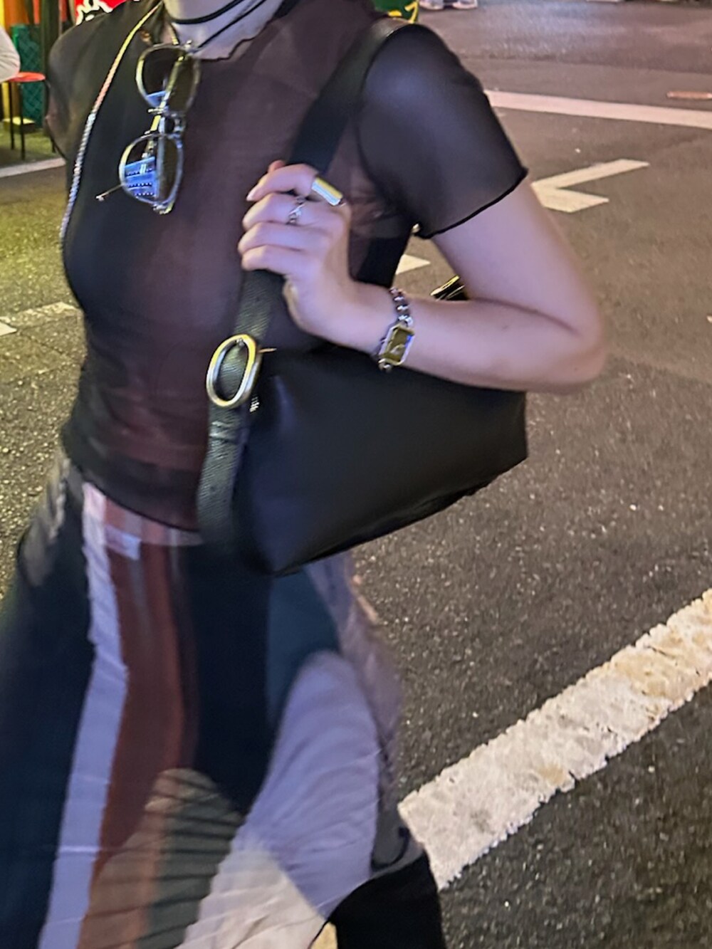 ブラック系のハンドバッグ、ブラック系のスニーカー、ブラック系のパンツを着用したレディースの秋コーディネートの2枚目の写真