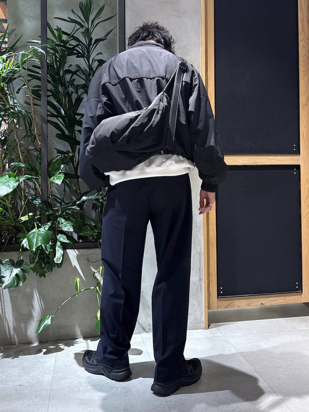 ブラック系のスニーカー、ブルー系のスラックス、ブラック系のショルダーバッグを着用したメンズの春コーディネートの9枚目の写真