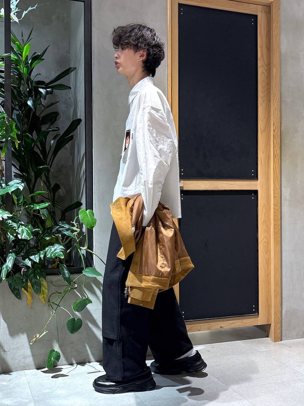 ブラック系のローファー、ブラック系のチノパンツ、ブラウン系のブルゾンを着用したメンズの秋コーディネートの3枚目の写真