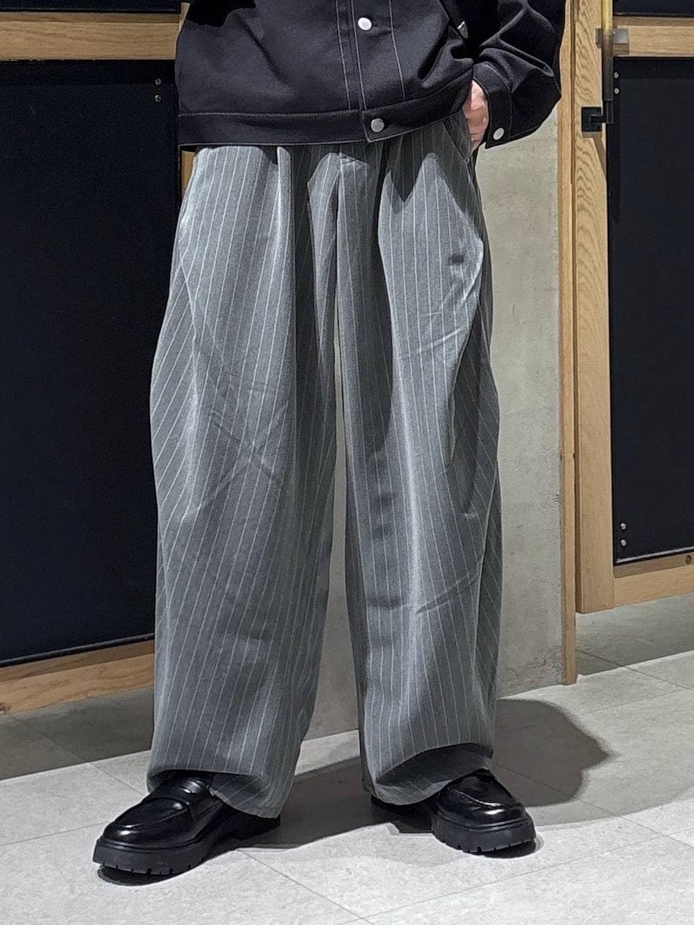 ブラック系のショルダーバッグ、ブラック系のドレスシューズ、ブラック系のブルゾンを着用したメンズの春コーディネートの3枚目の写真