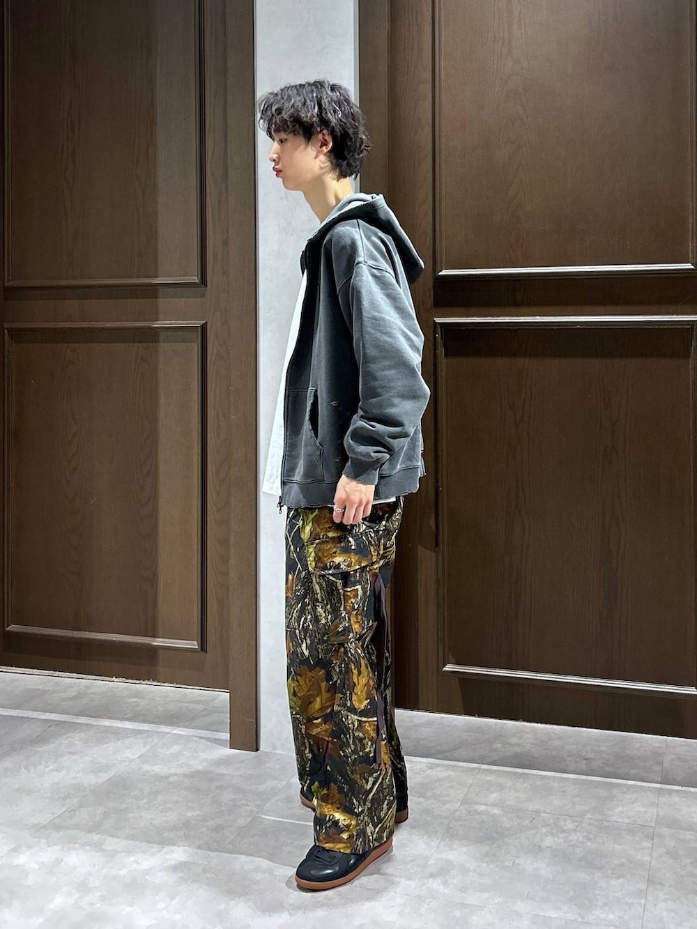 ブラック系のパーカー、ホワイト系のTシャツ/カットソー、ブラック系のスニーカーを着用したメンズの春コーディネートの3枚目の写真