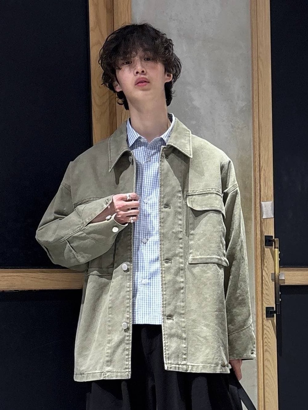 ブラック系のボストンバッグ、ブラック系のローファー、グリーン系のミリタリージャケットを着用したメンズの春コーディネートの7枚目の写真