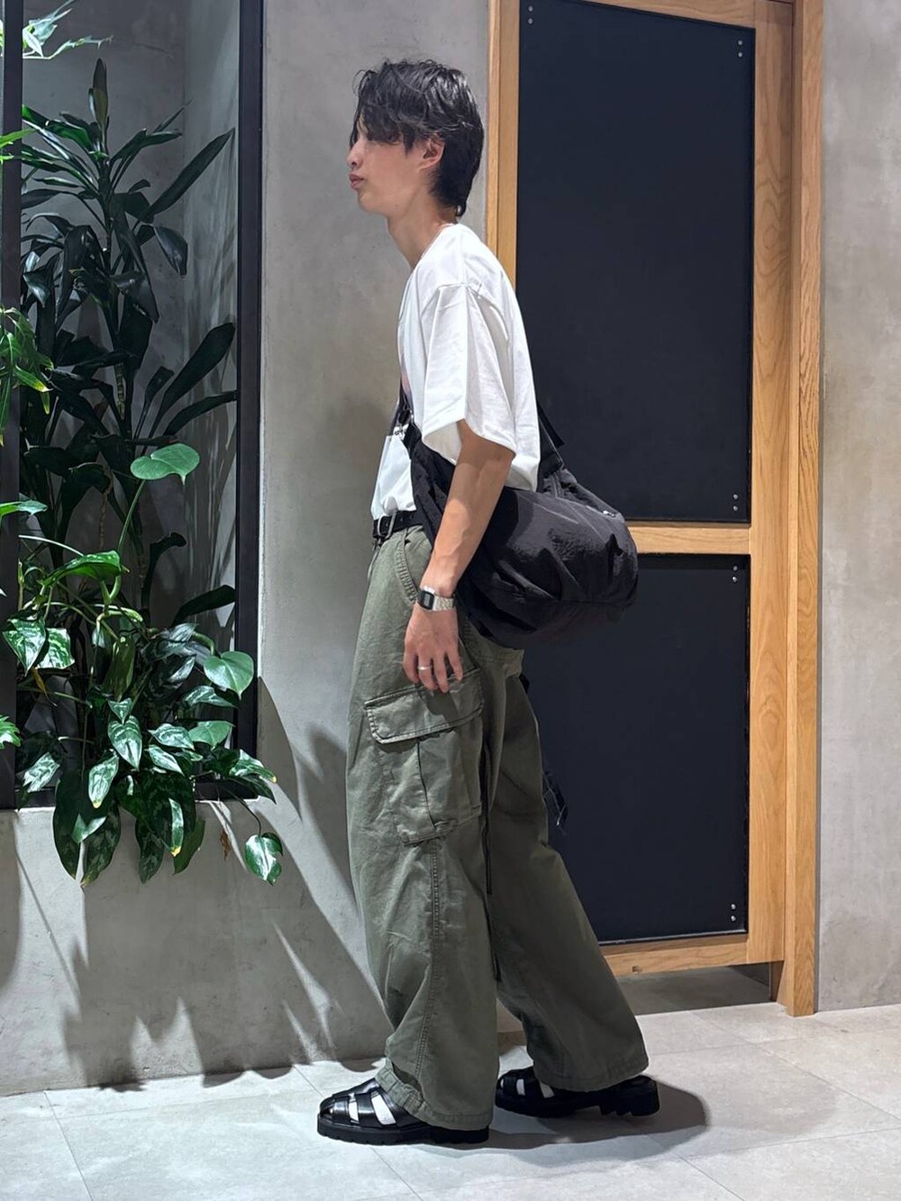 グリーン系のカーゴパンツ、ブラック系のサンダル、ブラック系のシャツ/ブラウスを着用したメンズの夏コーディネートの4枚目の写真