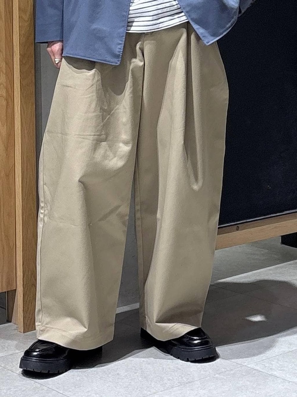 ブルー系のテーラードジャケット、ブラック系のドレスシューズ、ブラック系のショルダーバッグを着用したメンズの春コーディネートの3枚目の写真