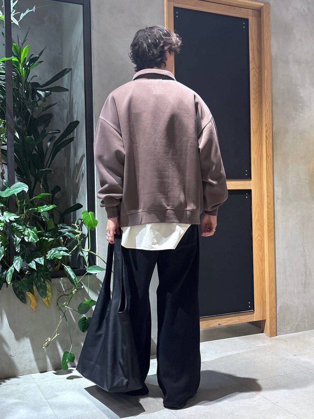 ブラック系のローファー、ブラック系のトートバッグ、ブラック系のデニムパンツを着用したメンズの秋コーディネートの5枚目の写真