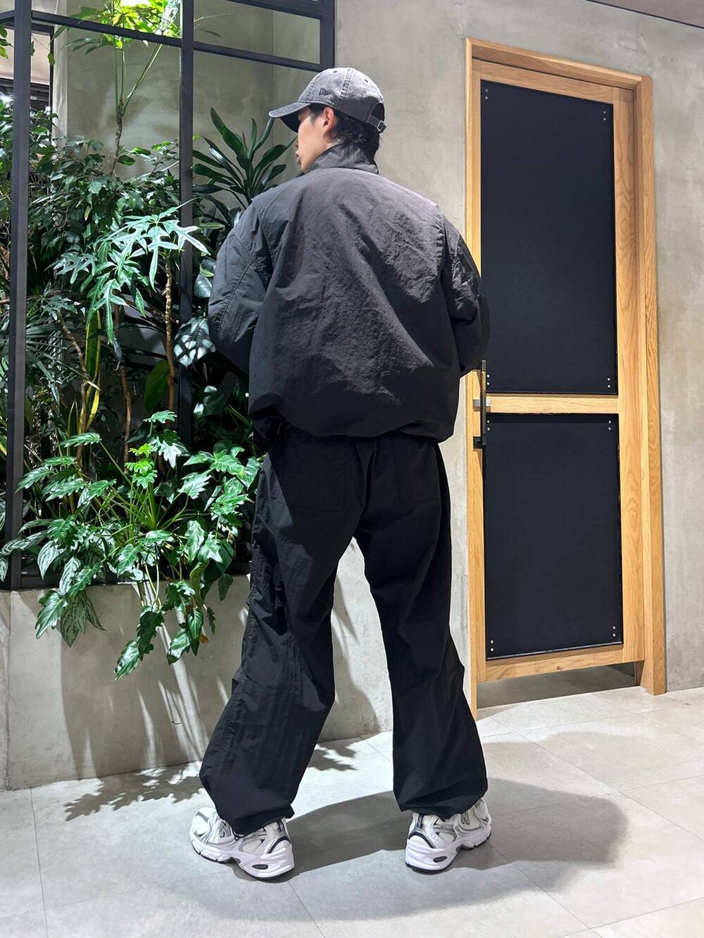 ホワイト系のスニーカー、ブラック系のブルゾン、ホワイト系のTシャツ/カットソーを着用したメンズの秋コーディネートの5枚目の写真