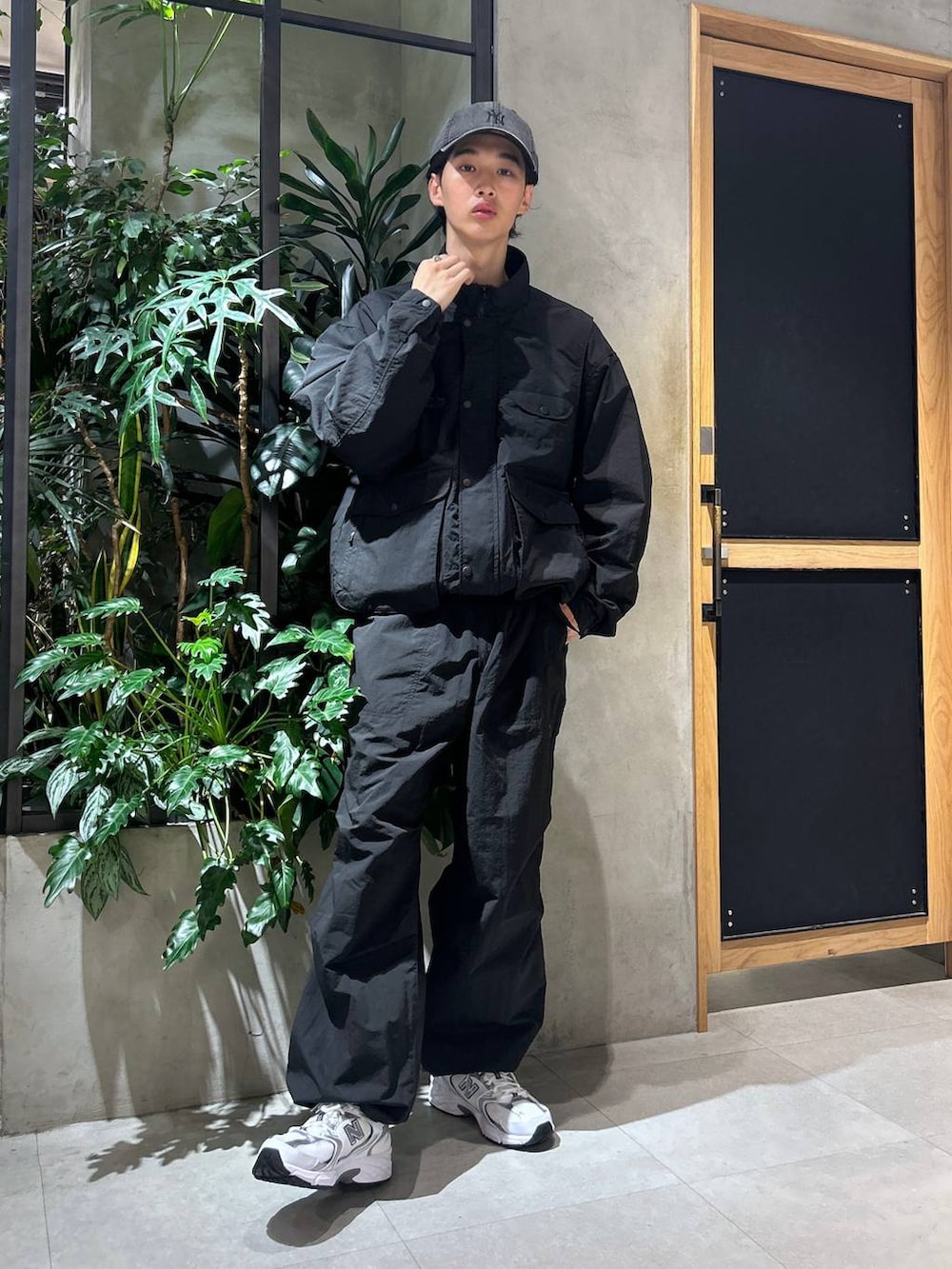 ホワイト系のスニーカー、ブラック系のブルゾン、ホワイト系のTシャツ/カットソーを着用したメンズの秋コーディネートの3枚目の写真