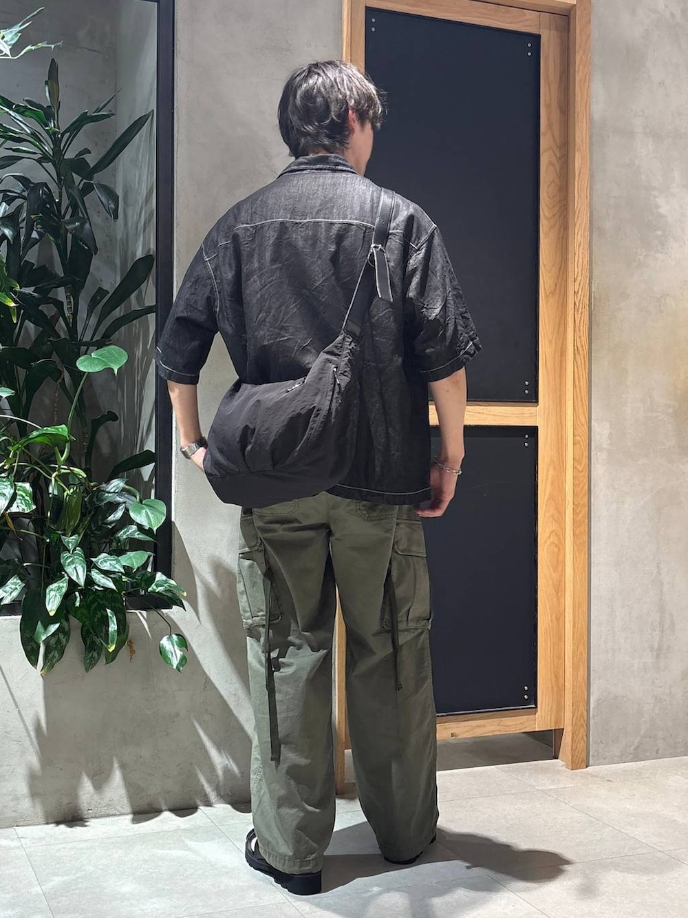 グリーン系のカーゴパンツ、ブラック系のサンダル、ブラック系のシャツ/ブラウスを着用したメンズの夏コーディネートの9枚目の写真
