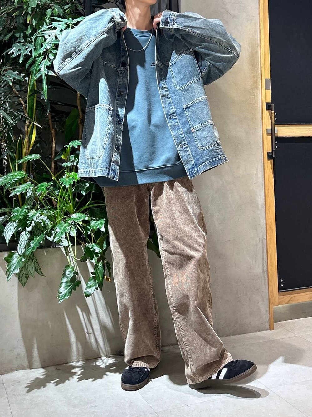 ブラック系のスニーカー、ブルー系のデニムジャケット、ホワイト系のTシャツ/カットソーを着用したメンズの秋コーディネートの2枚目の写真