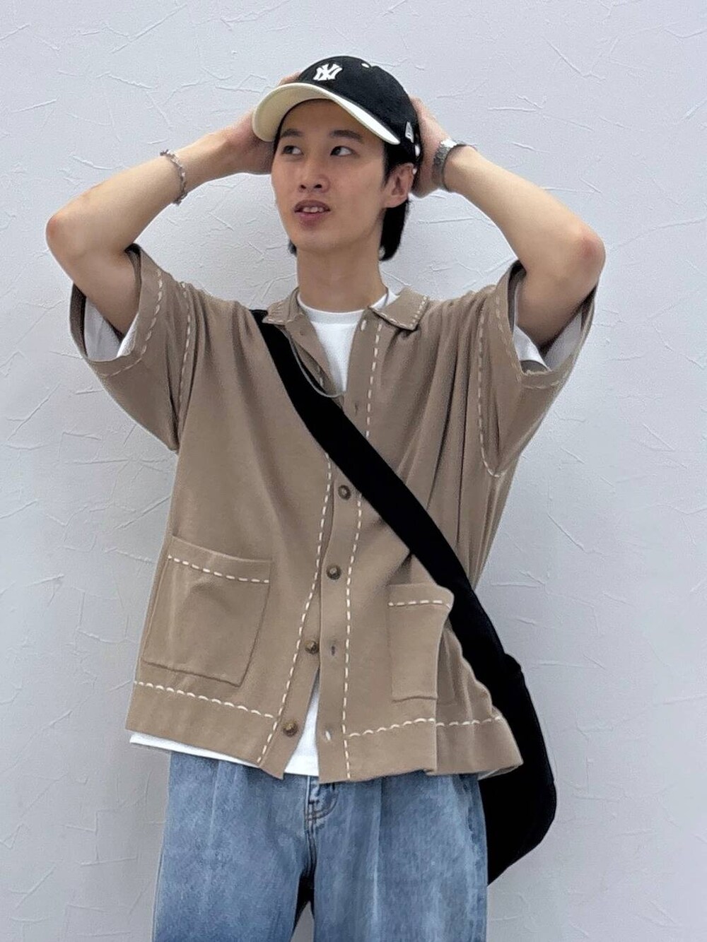 ブルー系のデニムパンツ、ベージュ系のカーディガン/ボレロ、ブラック系のサンダルを着用したメンズの夏コーディネートの2枚目の写真