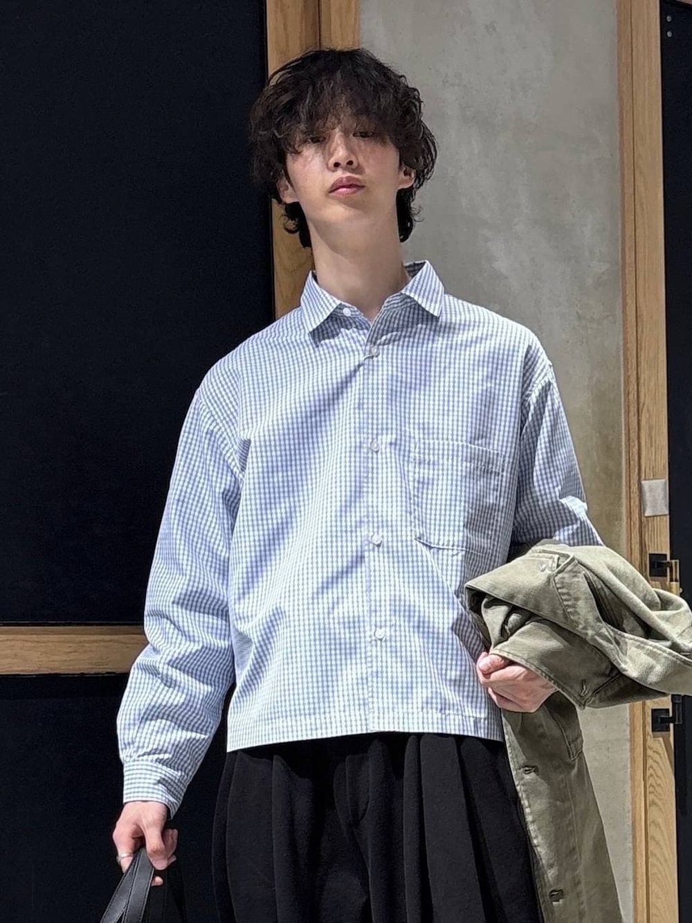 ブラック系のボストンバッグ、ブラック系のローファー、グリーン系のミリタリージャケットを着用したメンズの春コーディネートの2枚目の写真