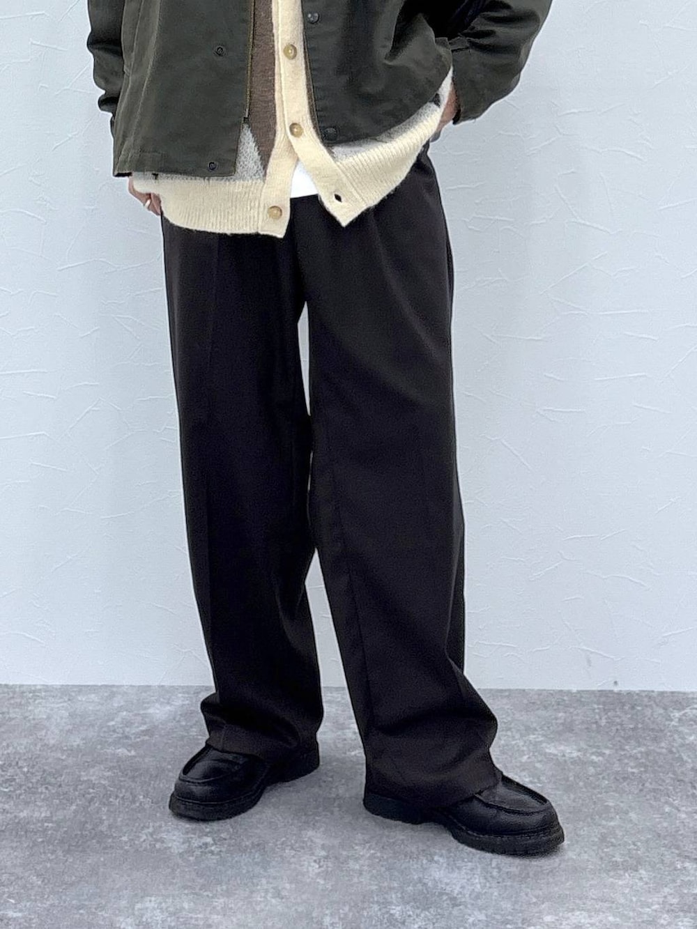 ホワイト系のカーディガン/ボレロ、ブラウン系のスラックス、グリーン系のブルゾンを着用したメンズの秋コーディネートの3枚目の写真