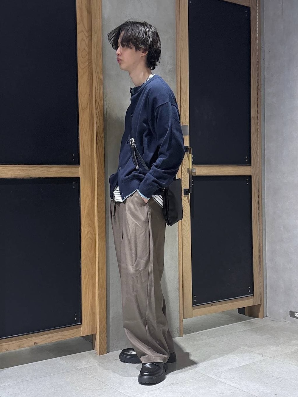 ブラック系のショルダーバッグ、ブラック系のドレスシューズ、ホワイト系のTシャツ/カットソーを着用したメンズの春コーディネートの4枚目の写真