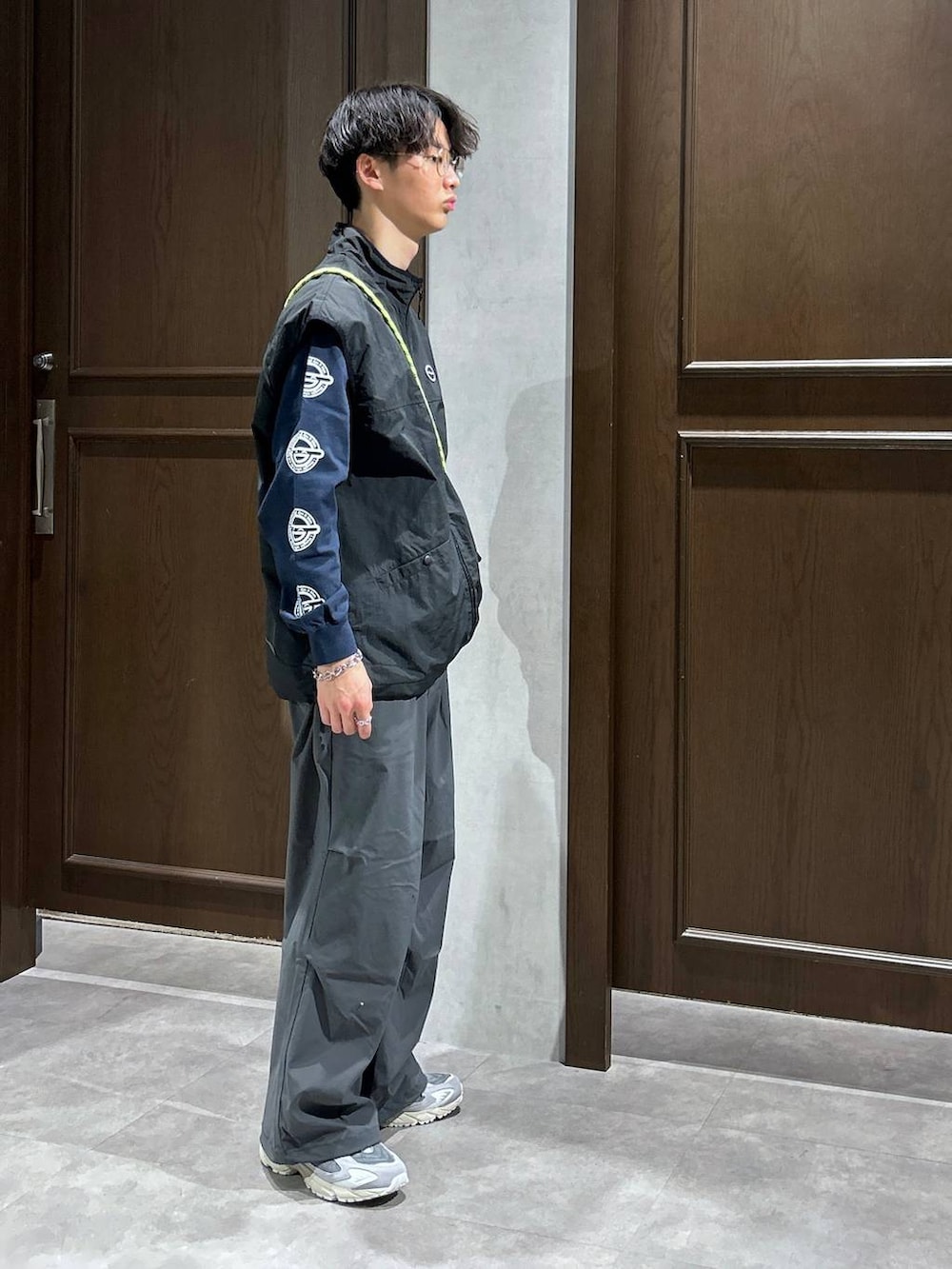 ブラック系のベスト、ブルー系のTシャツ/カットソー、グレー系のスウェットパンツを着用したメンズの春コーディネートの3枚目の写真