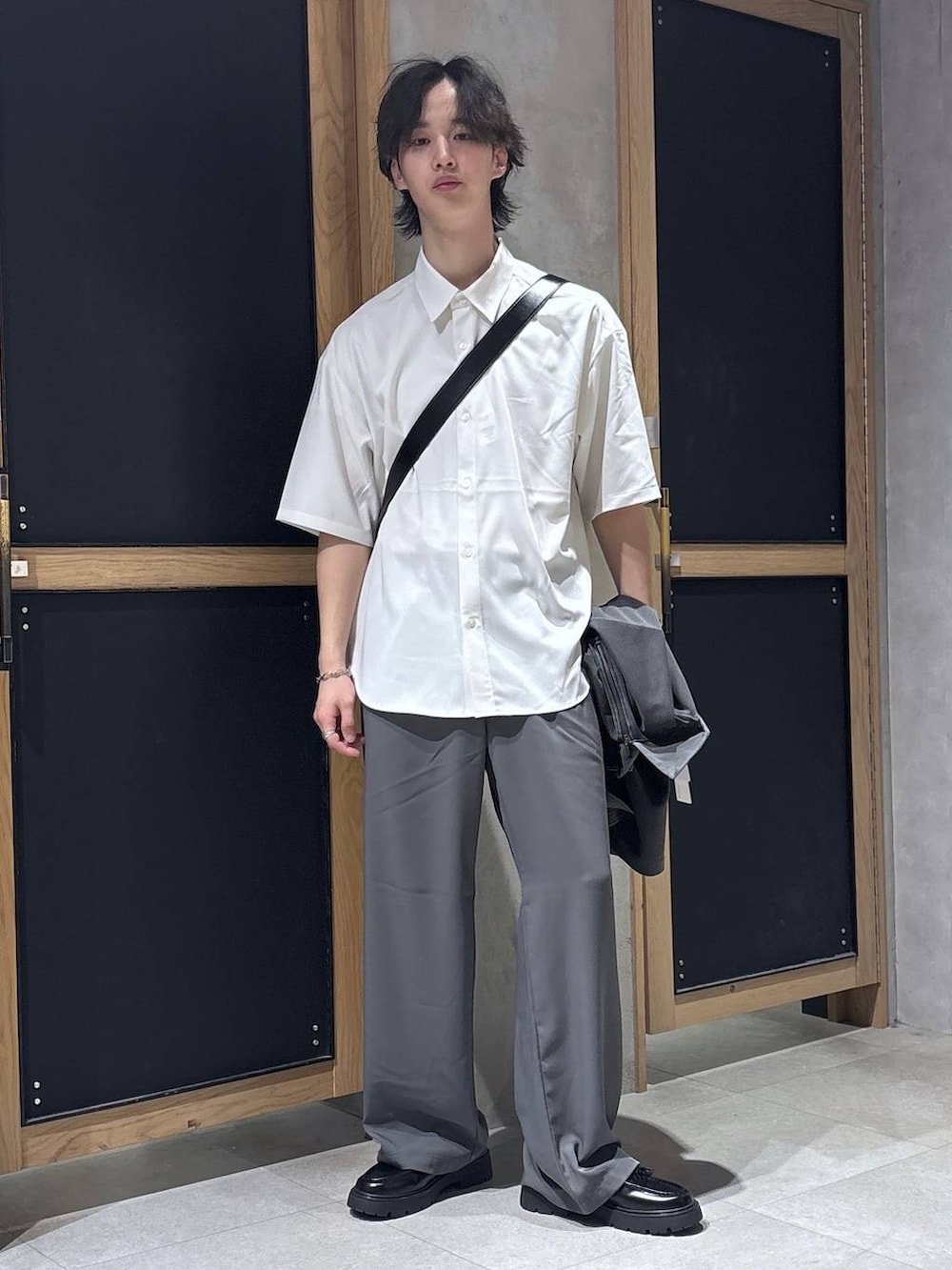 ホワイト系のシャツ/ブラウス、グレー系のスラックス、ブラック系のドレスシューズを着用したメンズの春コーディネートの6枚目の写真