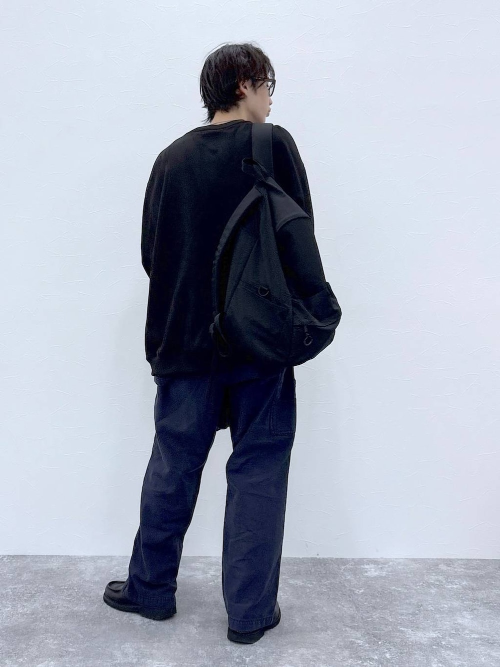 ブラック系のスウェット、ブラック系のブルゾン、ブラック系のバックパック/リュックを着用したメンズの秋コーディネートの5枚目の写真